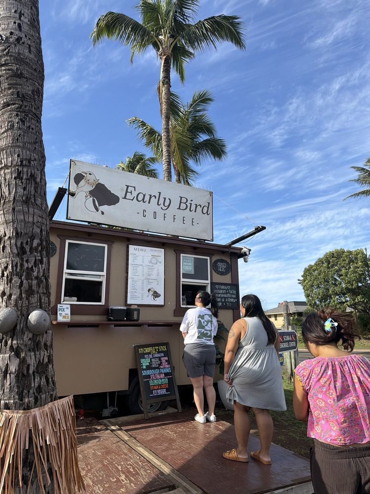 The Early Bird Coffee shack on South Kihei Road — a hand-painted bird sign under a palm tree, with customers ordering at the window.